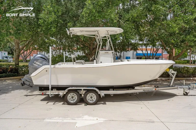 Slide: The Image of 2020 Release 210 RX boat on trailer, parked outdoors with trees in background. - 1