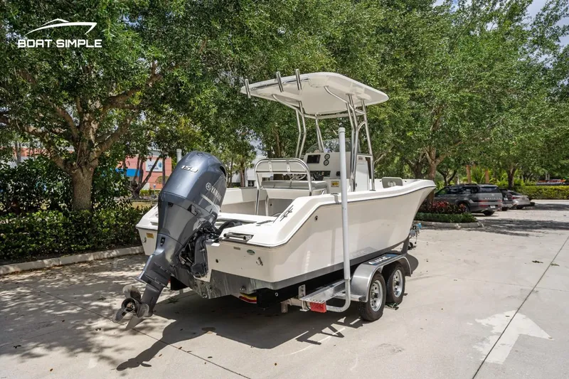 Slide: The Image of 2020 Release 210 RX boat on trailer, parked outdoors with trees in the background. - 3