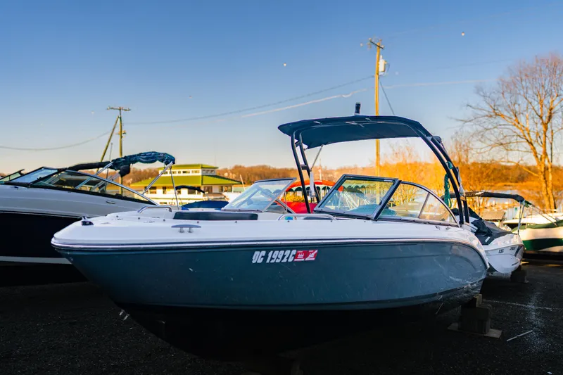 Slide: The Image of 2018 Chaparral 210 Suncoast boat docked outdoors under clear blue sky. - 7