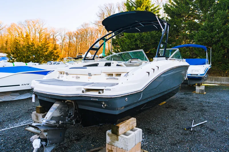 Slide: The Image of 2018 Chaparral 210 Suncoast boat on blocks, outdoor storage, surrounded by trees. - 9