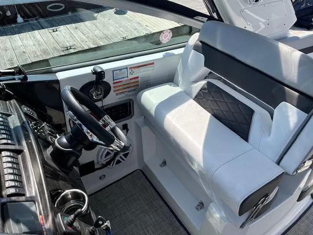 Slide: The Image of 2022 Monterey 295 Sport Yacht cockpit with modern steering and seating. - 16