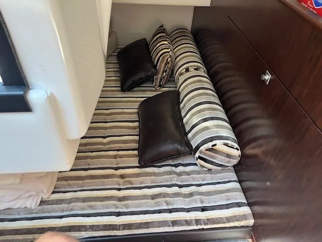 Slide: The Image of 2022 Monterey 295 Sport Yacht interior with striped cushions and pillows in cabin. - 28