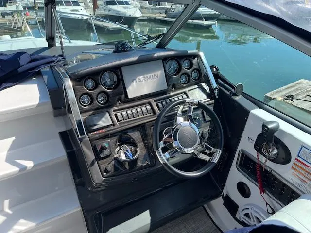 Slide: The Image of 2022 Monterey 295 Sport Yacht dashboard with Garmin navigation, docked at marina. - 6