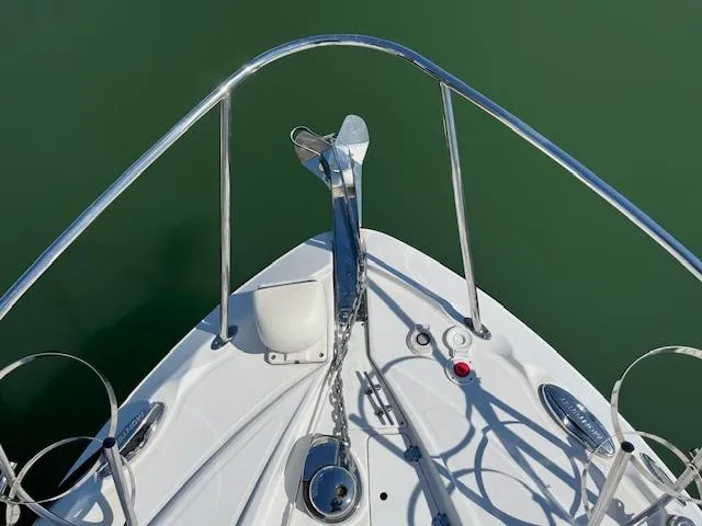 Slide: The Image of Bow of 2022 Monterey 295 Sport Yacht with anchor and railing, on calm green water. - 9
