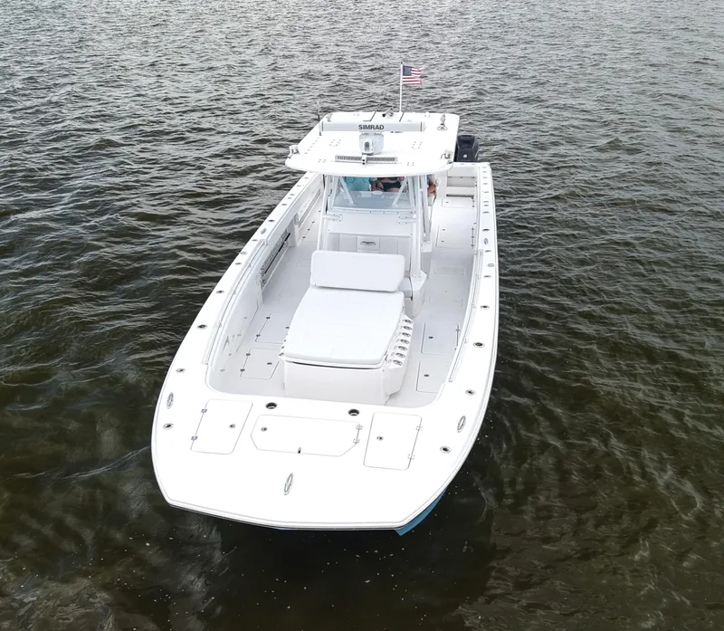 Slide: The Image of 2018 Invincible 40 Catamaran on water, aerial view, white hull, American flag. - 13