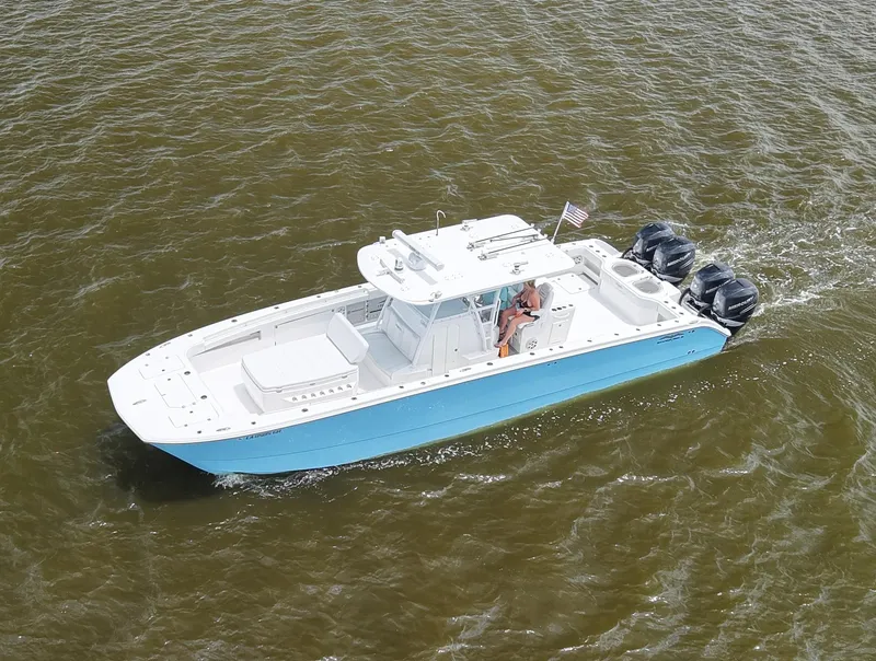 Slide: The Image of 2018 Invincible 40 Catamaran cruising on water, featuring triple outboard engines. - 16