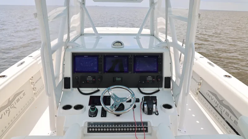 Slide: The Image of Invincible 40 Catamaran 2018 helm with advanced navigation displays and controls on open water. - 24