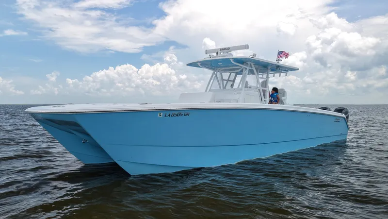 Slide: The Image of 2018 Invincible 40 Catamaran in blue on open water under cloudy sky. - 7