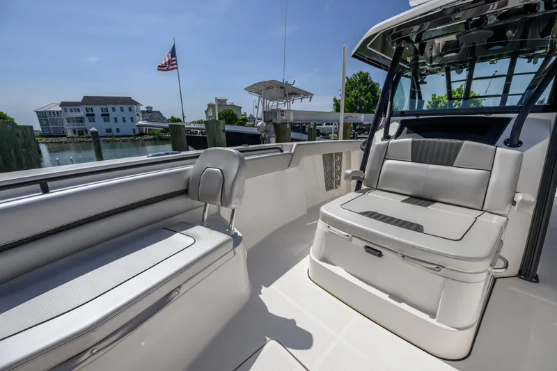 Slide: The Image of 2019 Wellcraft 352 Fisherman boat interior with seating, docked near waterfront homes. - 12