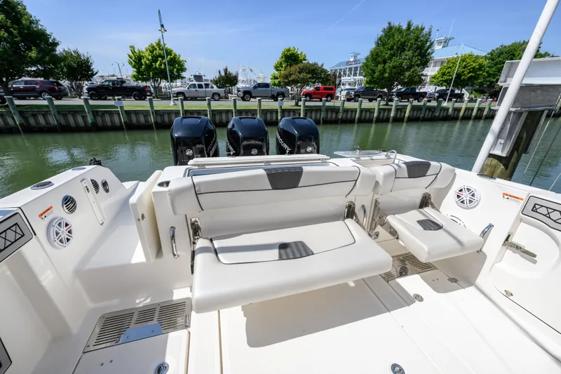 Slide: The Image of 2019 Wellcraft 352 Fisherman boat with seating and triple outboard motors docked by the water. - 19