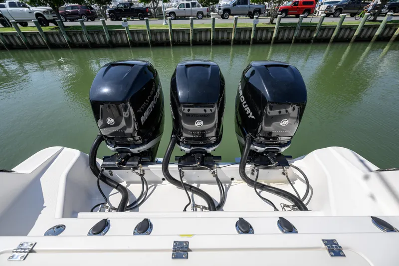 Slide: The Image of 2019 Wellcraft 352 Fisherman with triple Mercury outboard engines docked by the water. - 20