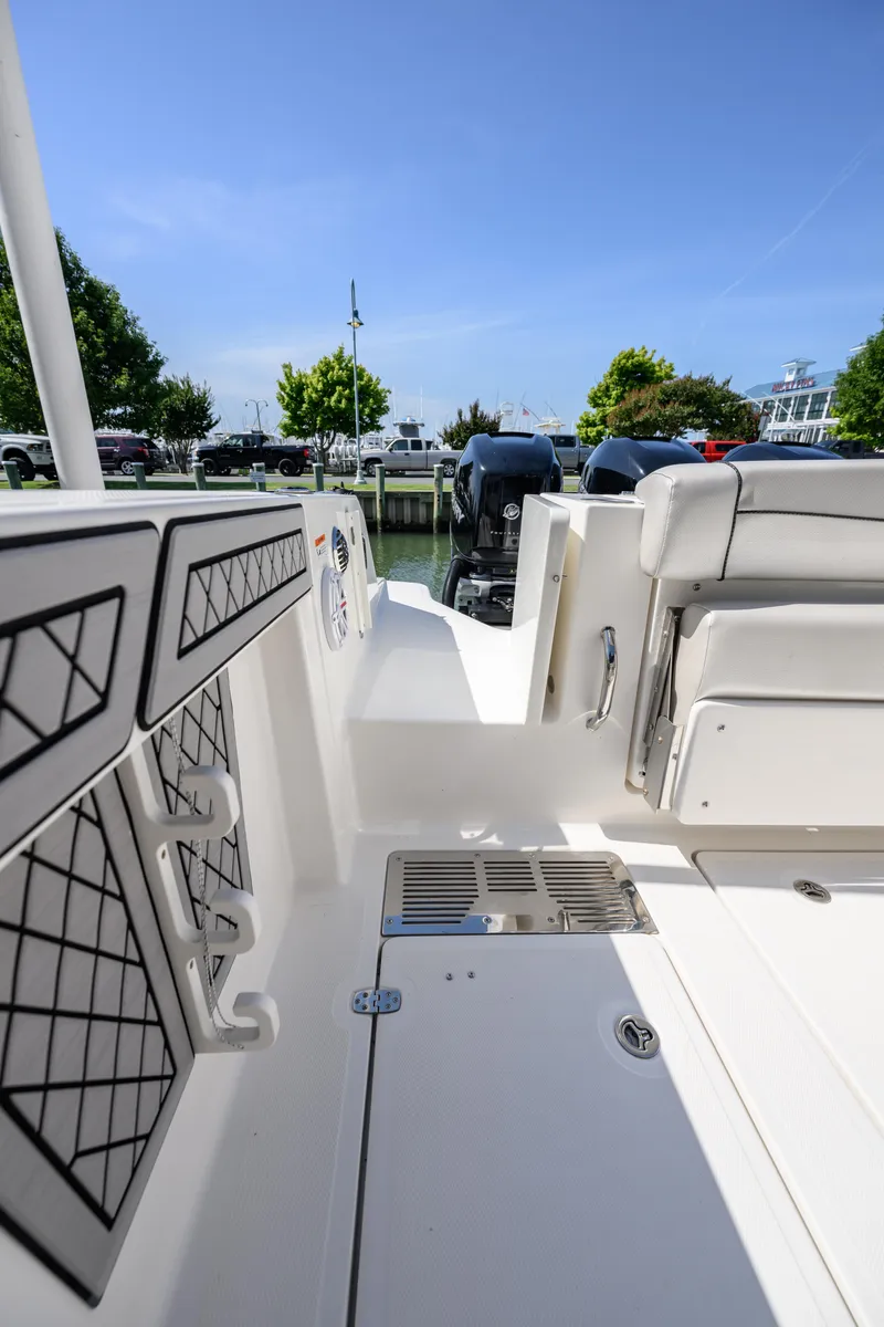 Slide: The Image of 2019 Wellcraft 352 Fisherman boat interior with seating and storage, docked under clear blue sky. - 21