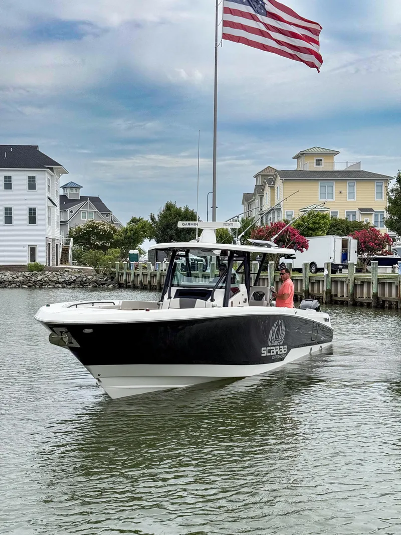 Slide: The Image of 2019 Wellcraft 352 Fisherman boat on water near dock, American flag in background. - 3