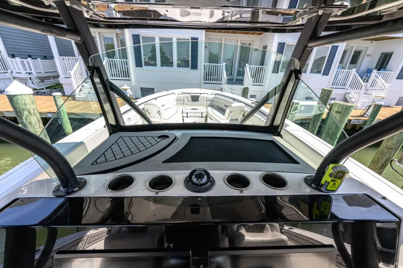 Slide: The Image of 2019 Wellcraft 352 Fisherman boat dashboard with cup holders and waterfront view. - 32