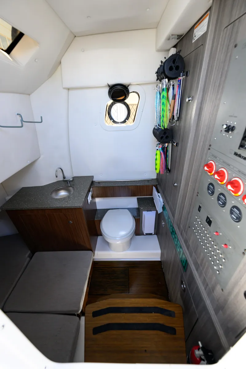 Slide: The Image of 2019 Wellcraft 352 Fisherman cabin interior with sink, toilet, and control panel. - 34