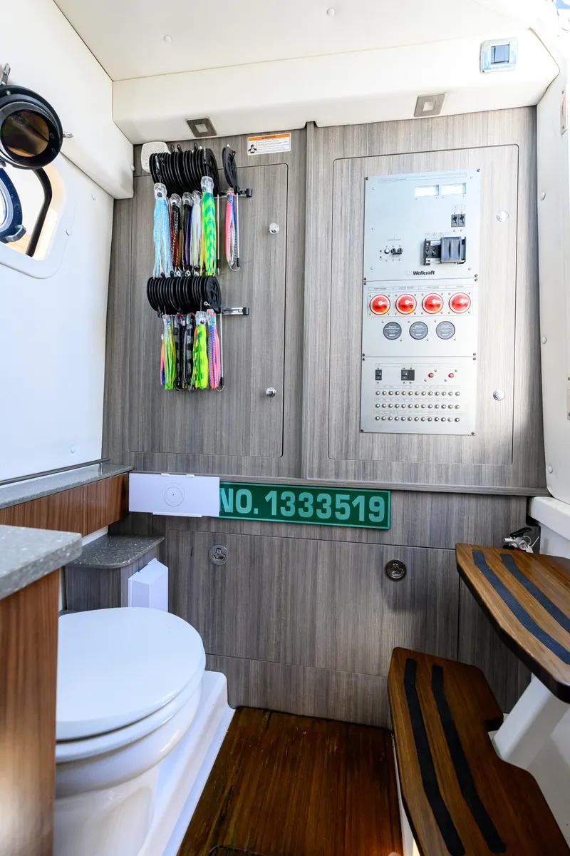 Slide: The Image of 2019 Wellcraft 352 Fisherman interior with control panel, fishing gear, and toilet. - 35