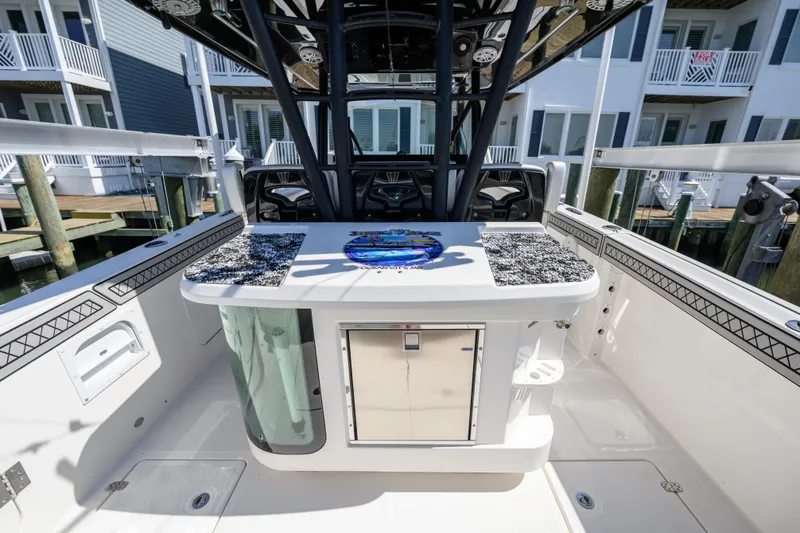 Slide: The Image of 2019 Wellcraft 352 Fisherman boat interior with fishing station and storage, docked near waterfront homes. - 5