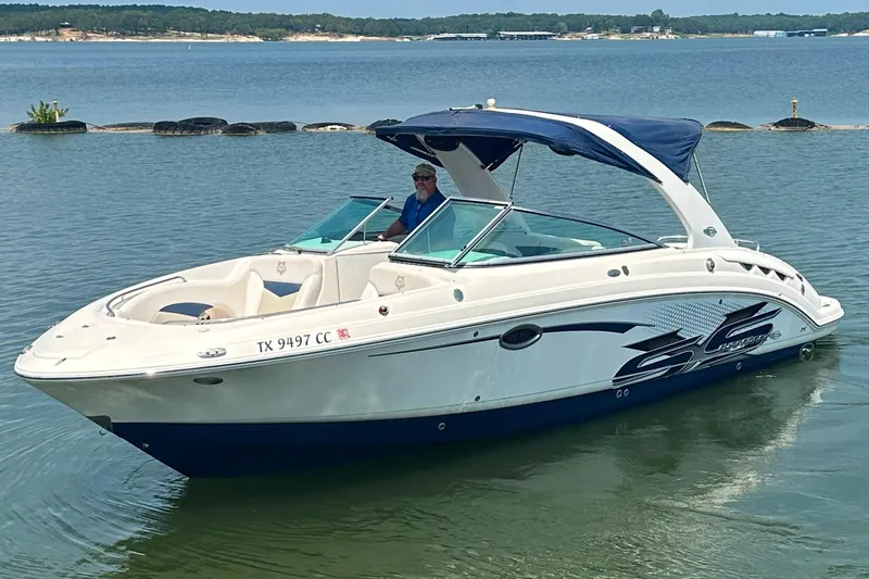The Image of 2011 Chaparral 287 SSX boat on calm water with blue canopy. - 0