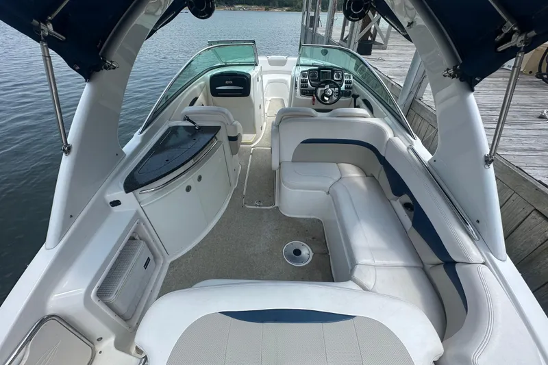Slide: The Image of 2011 Chaparral 287 SSX boat interior with seating and helm, docked by the water. - 12