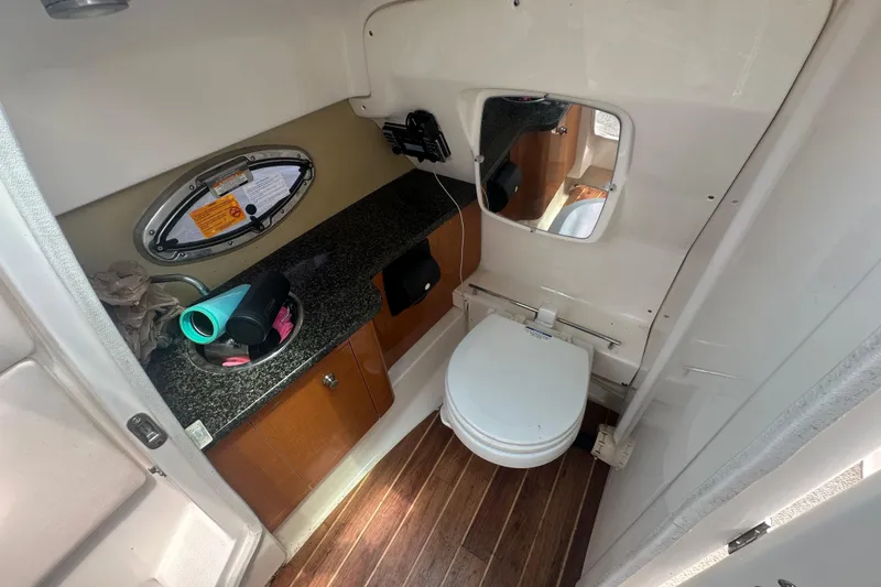 Slide: The Image of 2011 Chaparral 287 SSX boat bathroom with toilet, sink, and wooden flooring. - 33