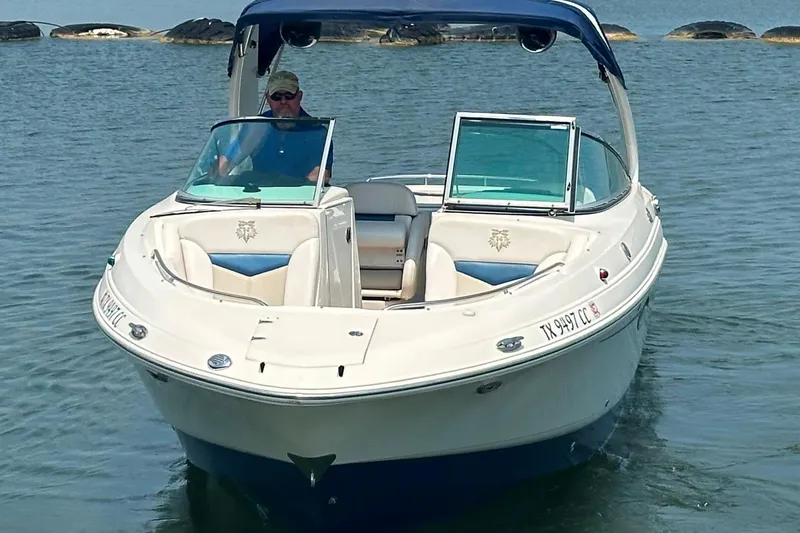 Slide: The Image of 2011 Chaparral 287 SSX boat cruising on calm water with a person at the helm. - 4
