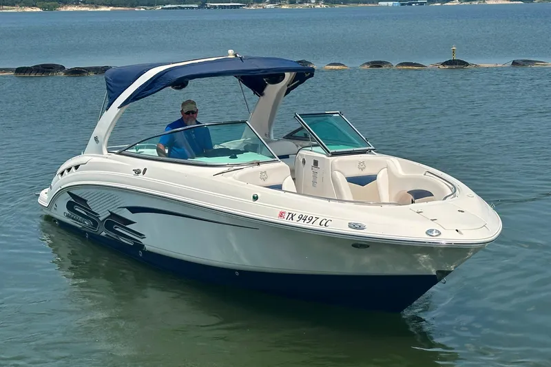 Slide: The Image of 2011 Chaparral 287 SSX boat on calm water with a blue canopy. - 5