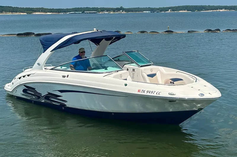 Slide: The Image of 2011 Chaparral 287 SSX boat on calm water with a blue canopy. - 6