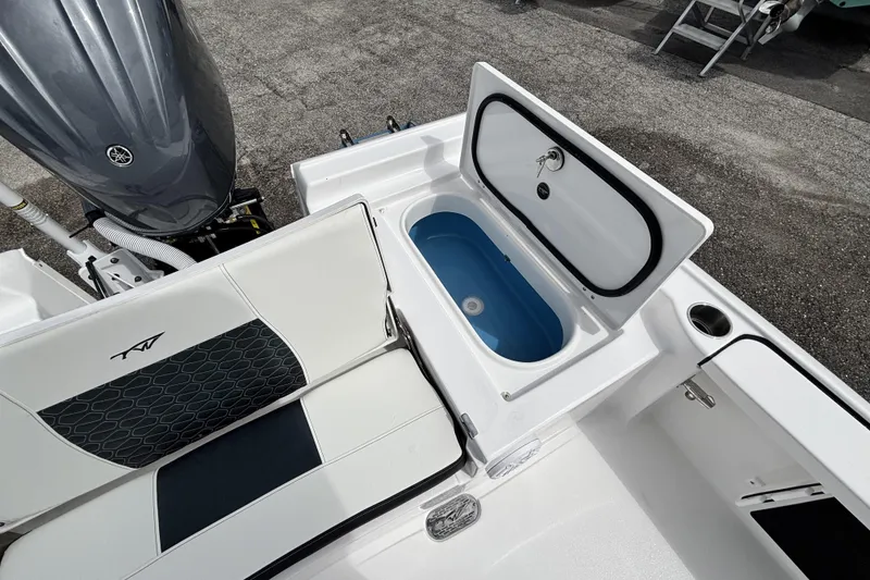 Slide: The Image of 2026 Tidewater 2410 Bay Max boat interior with open storage compartment and seating. - 13