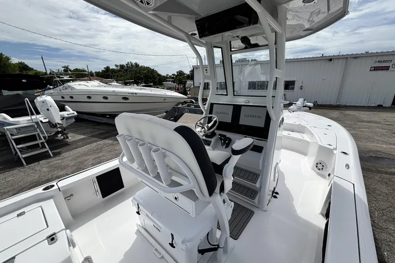 Slide: The Image of 2026 Tidewater 2410 Bay Max boat interior with Garmin displays, docked near other boats. - 16