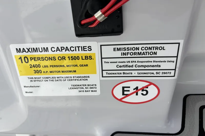 Slide: The Image of 2026 Tidewater 2410 Bay Max capacity and emission control labels, E15 fuel warning. - 22