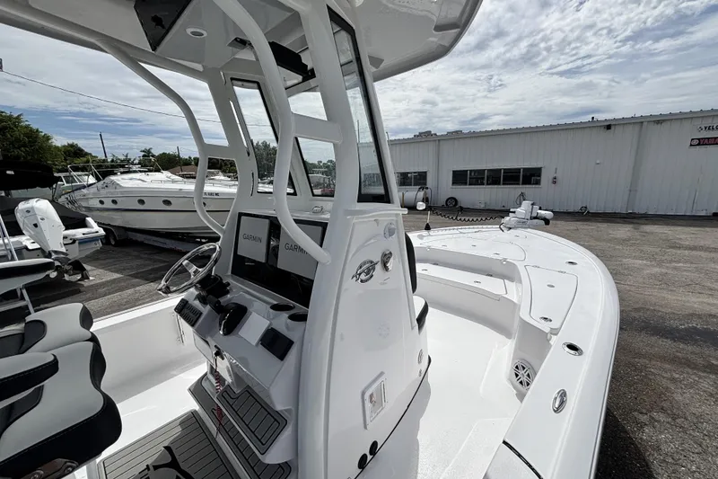 Slide: The Image of 2026 Tidewater 2410 Bay Max boat with modern console and seating, docked outdoors. - 23
