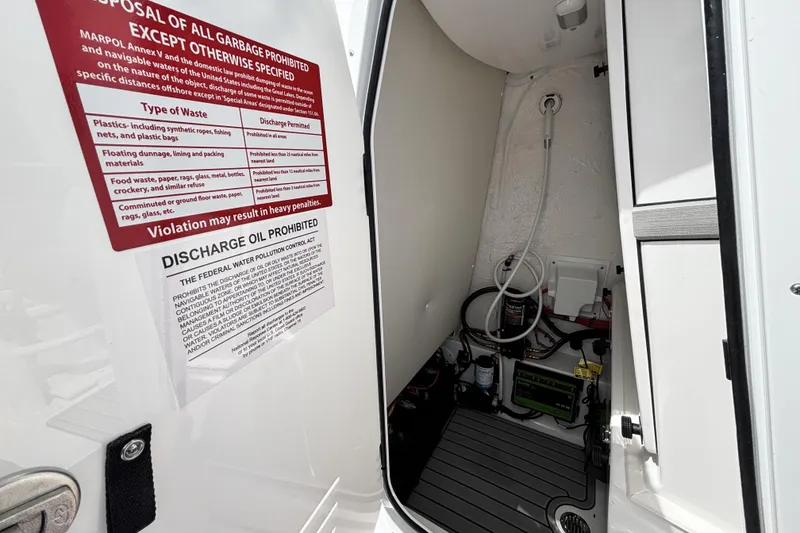 Slide: The Image of Interior of 2026 Tidewater 2410 Bay Max boat with waste disposal instructions. - 25
