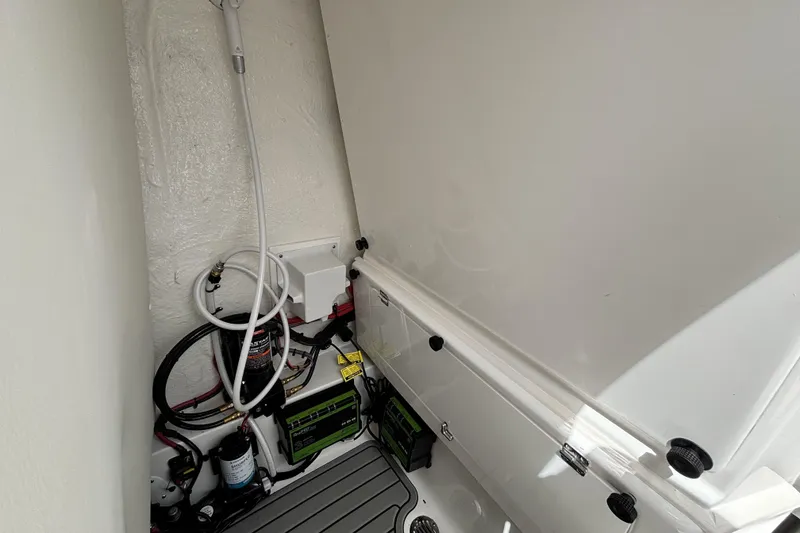 Slide: The Image of Interior view of 2026 Tidewater 2410 Bay Max boat's storage compartment with wiring and equipment. - 26