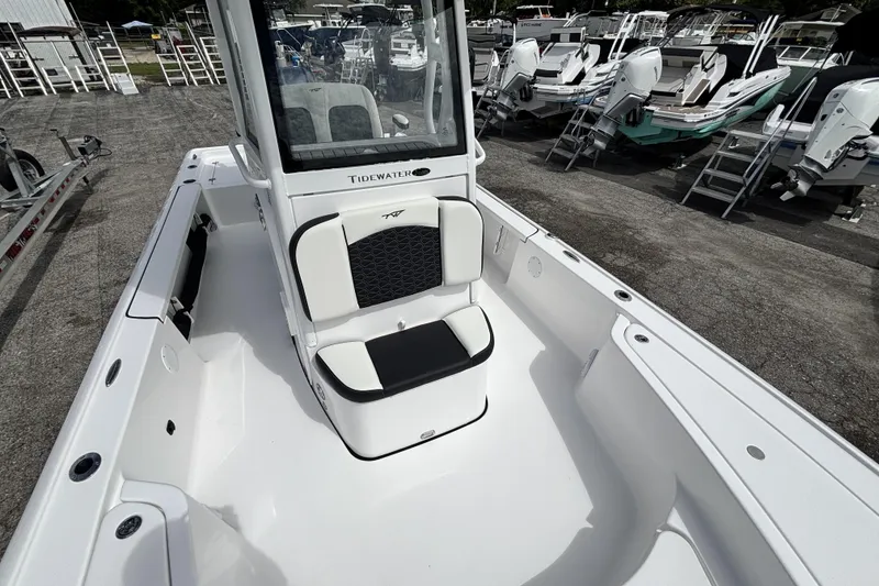 Slide: The Image of 2026 Tidewater 2410 Bay Max boat interior with seating, displayed in a marina setting. - 28