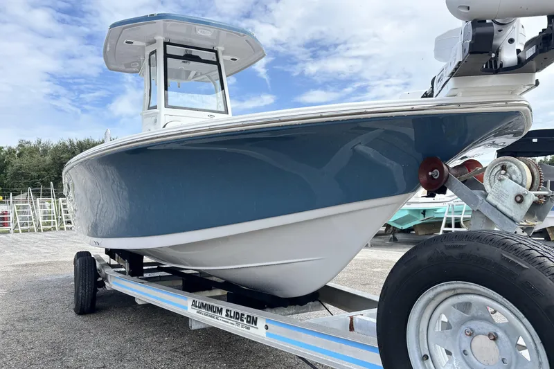 Slide: The Image of 2026 Tidewater 2410 Bay Max boat on trailer, blue and white hull, clear sky background. - 3