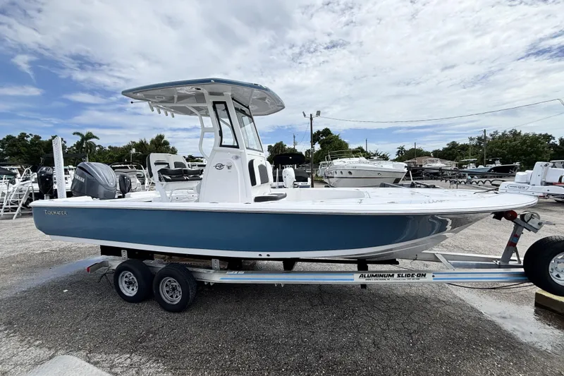Slide: The Image of 2026 Tidewater 2410 Bay Max boat on trailer, parked outdoors under cloudy sky. - 4