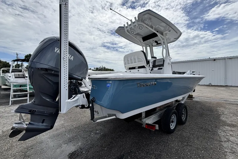 Slide: The Image of 2026 Tidewater 2410 Bay Max boat with Yamaha engine on trailer, under cloudy sky. - 5