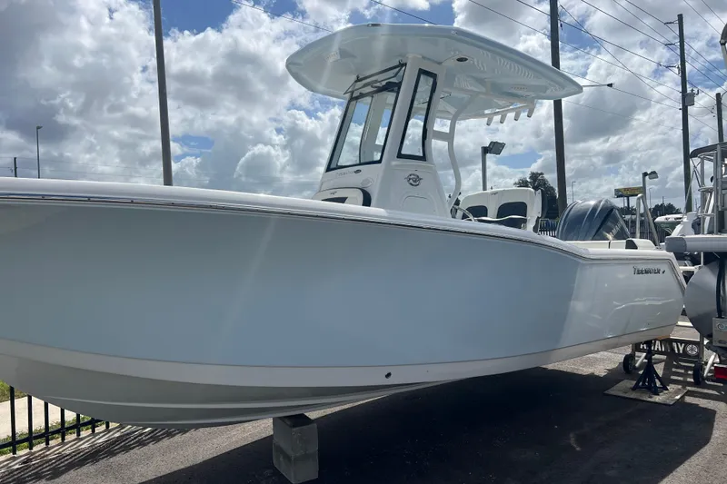 Slide: The Image of 2025 Tidewater 232 LXF boat displayed outdoors under cloudy sky. - 1
