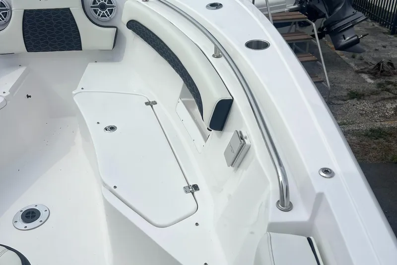 Slide: The Image of 2025 Tidewater 232 LXF boat interior with seating, speakers, and stainless steel railings. - 13