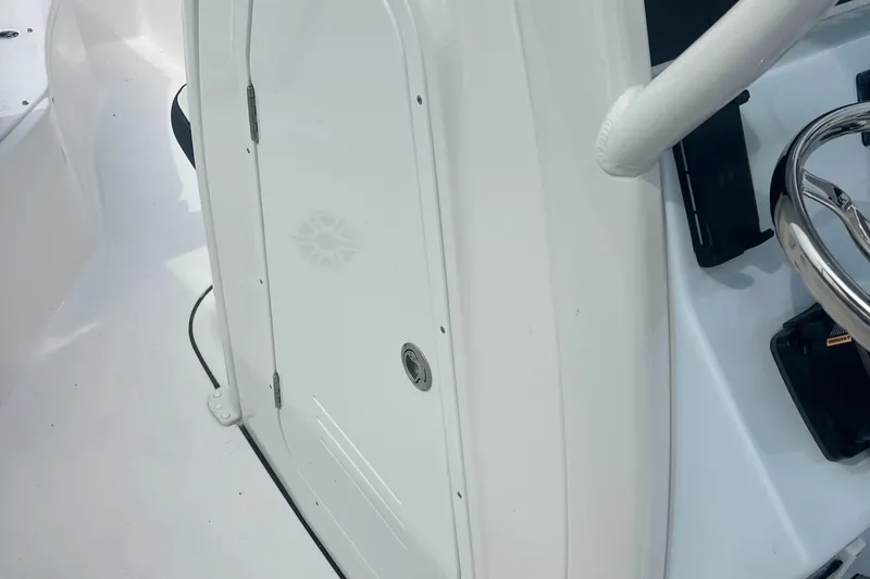 Slide: The Image of 2025 Tidewater 232 LXF boat interior, featuring a sleek white console and steering wheel. - 16