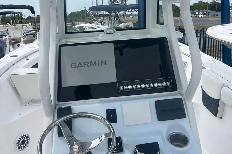 Slide: The Image of 2025 Tidewater 232 LXF boat dashboard with Garmin navigation system and steering wheel. - 5