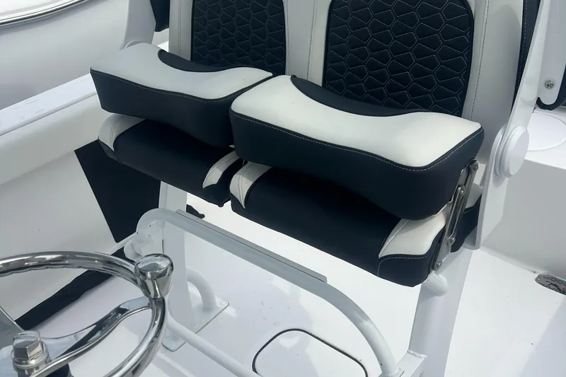 Slide: The Image of 2025 Tidewater 232 LXF boat seating with black and white cushioned design. - 7