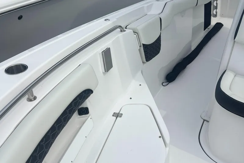 Slide: The Image of 2025 Tidewater 232 LXF boat interior with white seating and cup holder. - 9