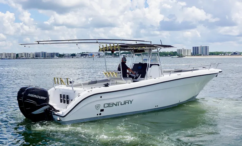 The Image of Century 3100 boat from 2000 on water, featuring Mercury engines, with cityscape in background. - 1