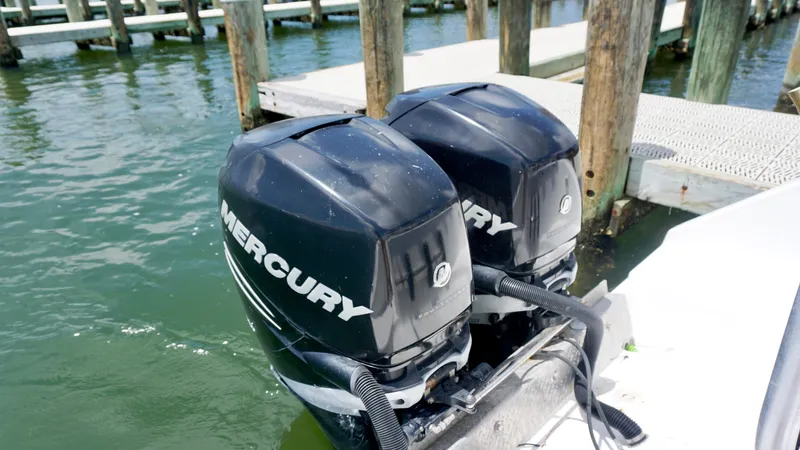 Slide: The Image of Twin Mercury outboard motors on a 2000 Century 3100 boat at a dock. - 17