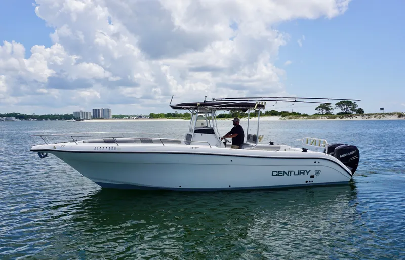 Slide: The Image of Century 3100 boat from 2000 on calm water, with a person at the helm. - 4