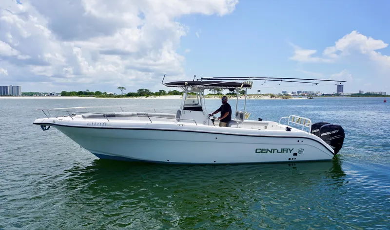 Slide: The Image of Century 3100 boat from 2000 on water, clear sky, person steering. - 5