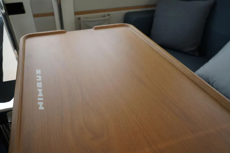 Slide: The Image of Wooden table with "Nimbus" logo inside 2024 Nimbus Commuter9 C9, featuring modern interior design. - 22