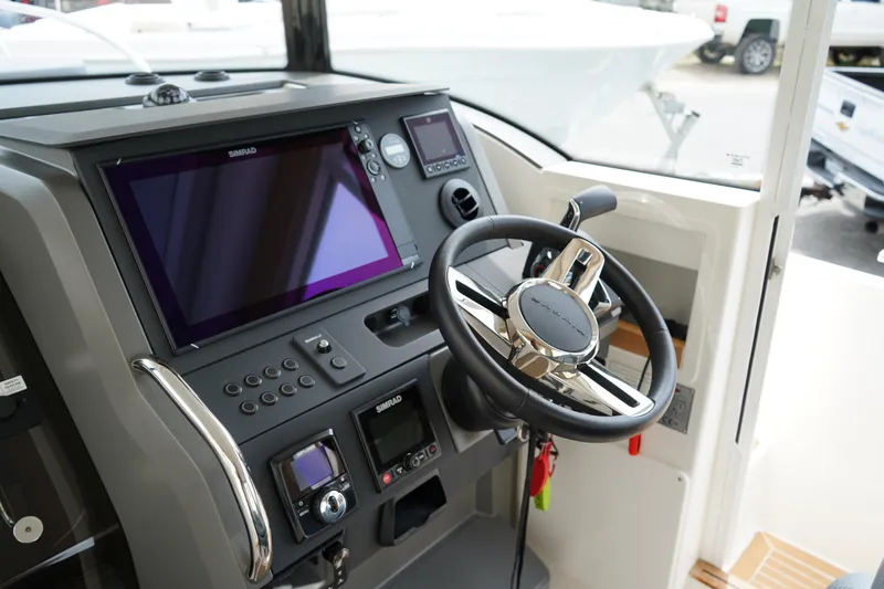 Slide: The Image of 2024 Nimbus Commuter9 C9 boat dashboard with steering wheel and navigation controls. - 32