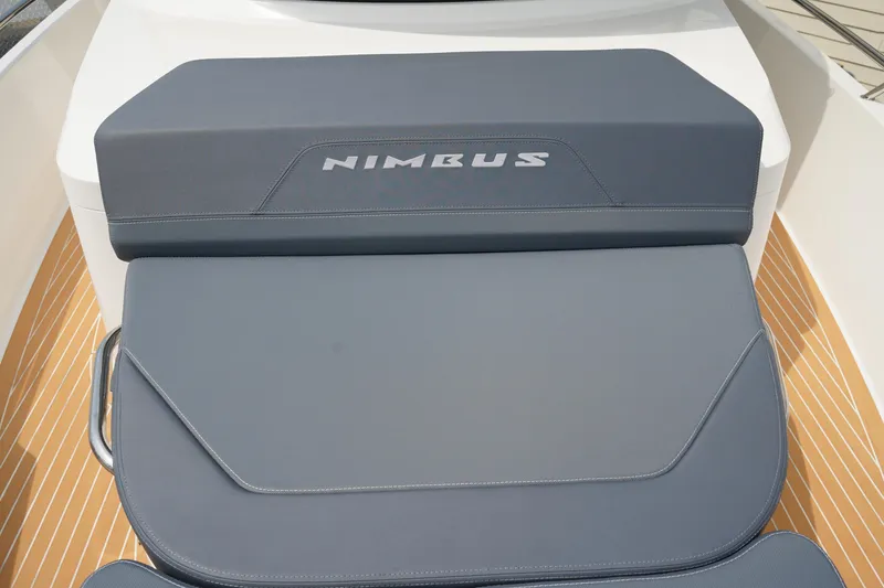 Slide: The Image of 2024 Nimbus Commuter9 C9 boat seat with logo, featuring sleek gray upholstery. - 49